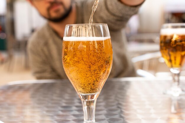 Mann gießt Bier in ein Glas