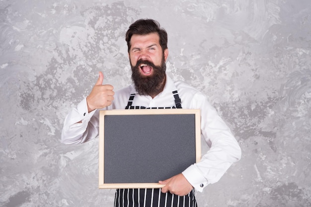 Foto mann gut aussehender gastfreundlicher restaurantkellner mit speziellem rezeptkonzept des tafelkopierraums