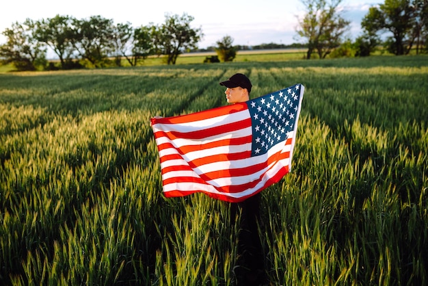 Mann hält die amerikanische USA-Flagge, Patriot hebt die nationale amerikanische Flagge, Unabhängigkeitstag, 4. Juli