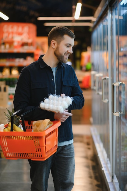 Mann hält Eierkarton im Supermarkt Eierkarton kaufen Karton Mann hält Überprüfung des Verbraucherkonzepts