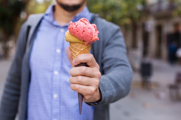 Mann hält ein Eis auf der Straße