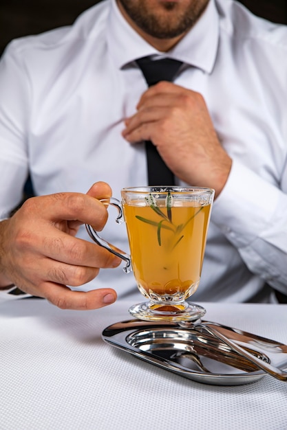 Foto mann hält ein heißes alkoholisches getränk in einem restaurant
