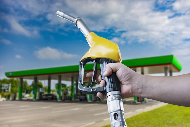 Mann hält eine Betankungspistole in der Hand, um Autos zu betanken Tankstelle mit Diesel- und Benzinkraftstoff in der Nähe