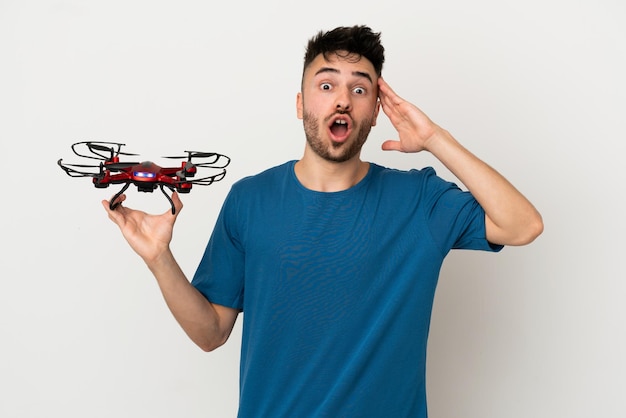 Mann hält eine Drohne isoliert auf weißem Hintergrund mit Überraschungsausdruck