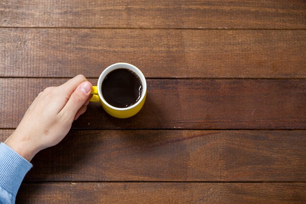 Mann hält eine Tasse Kaffee