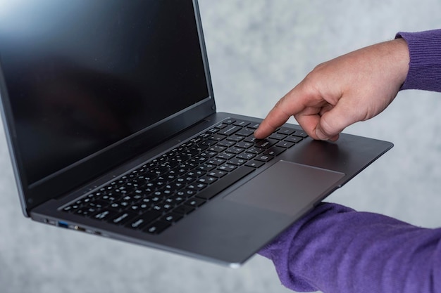 Mann hält einen Laptop in seinen Händen auf hellem Hintergrund