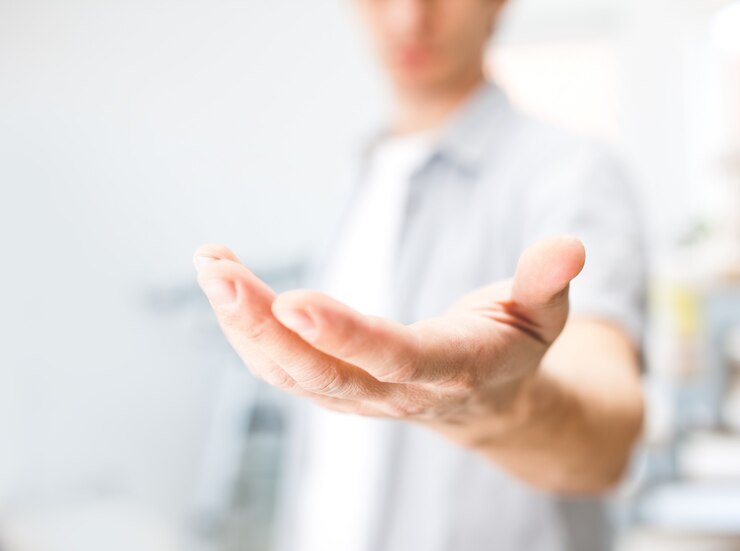 Mann hält etwas an seiner Hand