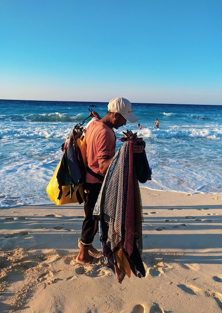 Foto mann hält handmaidens am strand vor klarem himmel