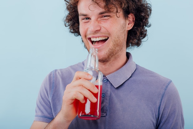 Mann hält in seiner Hand eine Flasche Getränk