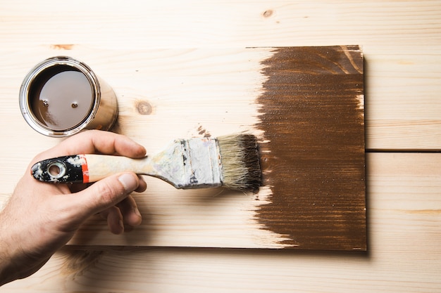 Mann hält Pinsel auf dem Holz