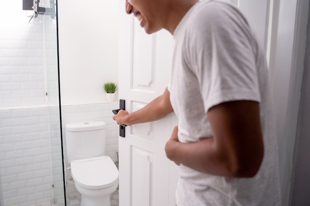 Mann hält seine bauchschmerzen und geht zur toilette