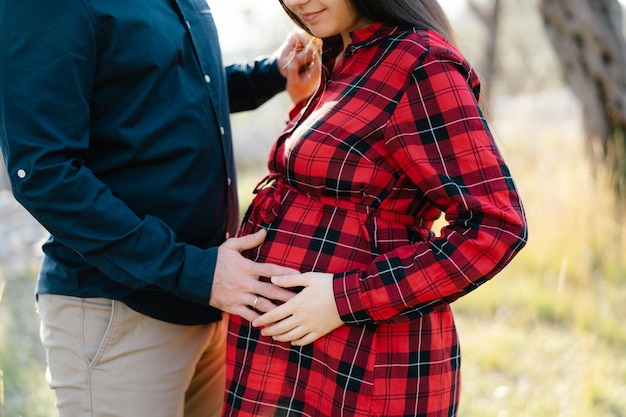 Mann hält seine Hand auf dem Bauch einer schwangeren Frau Nahaufnahme