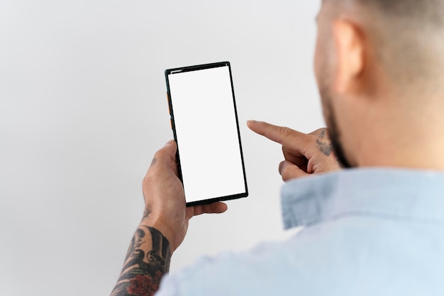 Mann hält Smartphone und nutzt mobile App zum Online-Shopping, isoliert auf weißem Hintergrund