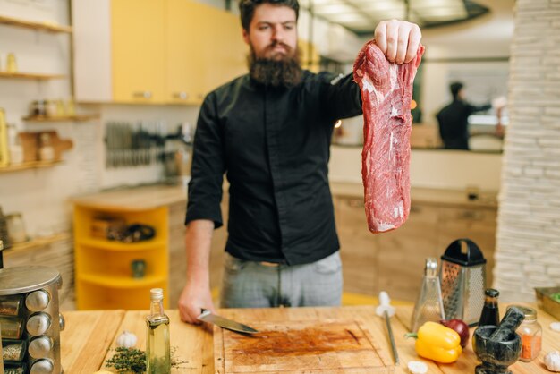 Mann hält Stück frisches rohes Fleisch