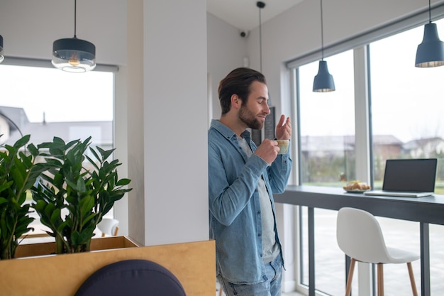 Mann hält Tasse Kaffeearoma inhalieren