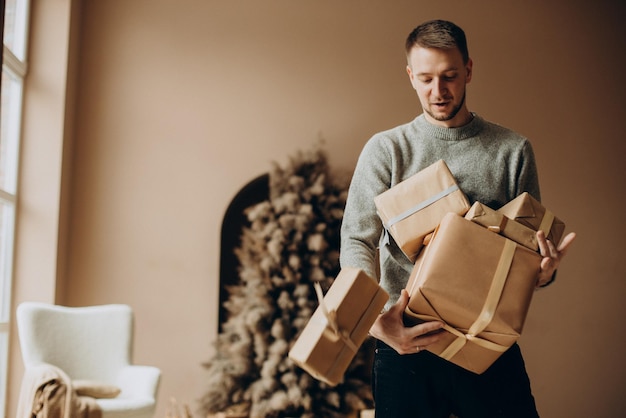 Mann hält viele Weihnachtsgeschenke