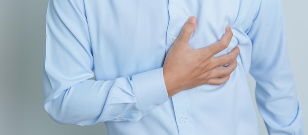 Mann Hand hält Brustschmerzen Herzkrankheit Angina-Krankheit und Symptom Herzinfarkt-Krankheit Herz-Kreislauf-Atherosklerose Hypertensive Welt Herztag und Gesundheitskonzept