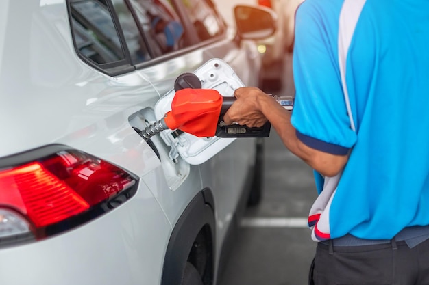 Mann hand tankt Auto Benzin Zapfpistole im Fahrzeug an der Tankstelle Ölpreis Erdölwirtschaft Inflation und Rohstoffkonzept
