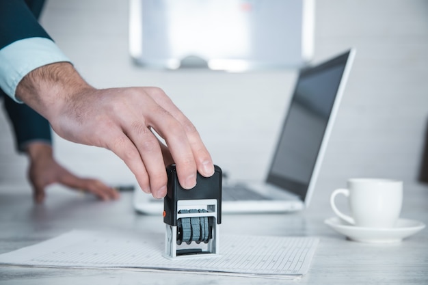 Mann Handversiegelung mit Computer auf dem Tisch