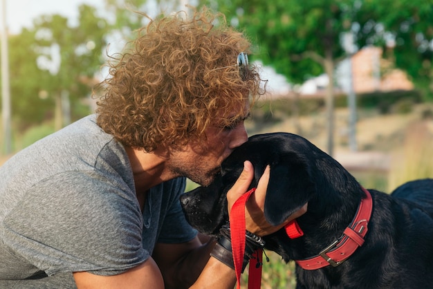 Mann hat Spaß und spielt mit seinem Hund im Park.