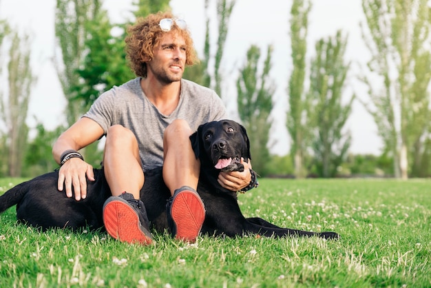 Mann hat Spaß und spielt mit seinem Hund im Park.