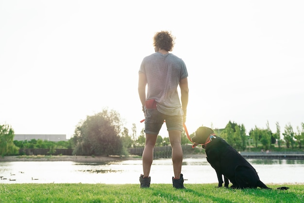 Mann hat Spaß und spielt mit seinem Hund im Park.