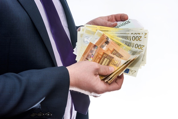 Mann im Anzug bietet Euro-Banknoten hautnah