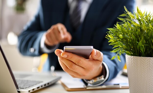 Mann im Anzug hält den Handy
