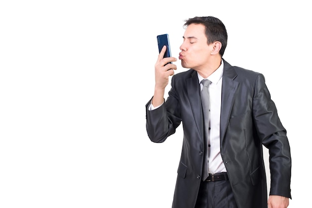 Mann im Anzug küsst Smartphone im Studio