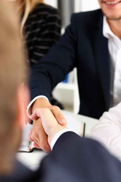 Mann im Anzug schütteln sich die Hand als Hallo im Büro