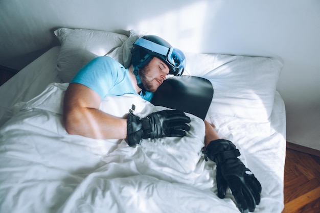 Mann im Bett mit Snowboard-Skibrille und Helm