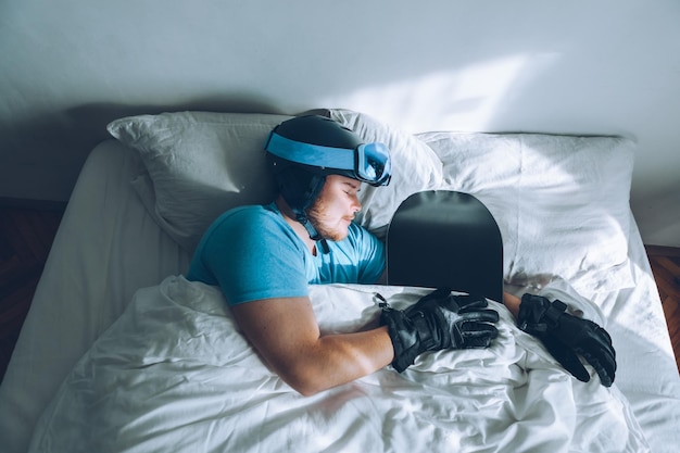 Mann im Bett mit Snowboard-Skibrille und Helm