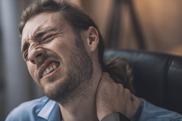 Mann im blauen Hemd, das müde schaut