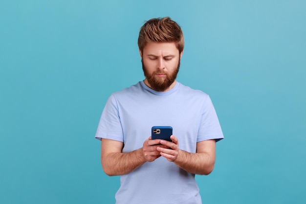 Mann im blauen T-Shirt SMS-Nachricht in sozialen Medien auf dem Handy über mobile Netzwerkdienste