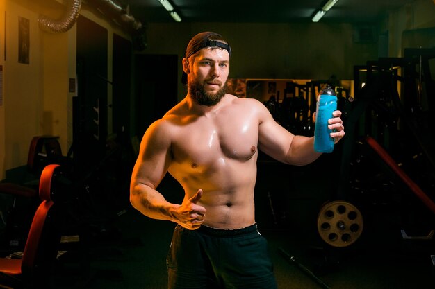 Mann im Fitnessstudio mit Shaker