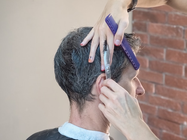 Mann im Friseurstuhl, Friseur Haarschnitt seine Haare. Friseur.