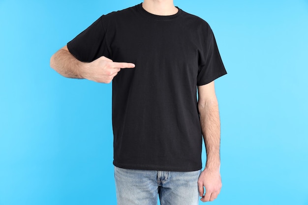 Mann im leeren schwarzen T-Shirt auf blauem Hintergrund