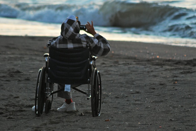 Mann im Rollstuhl am Strand