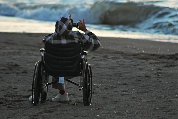 Foto mann im rollstuhl am strand