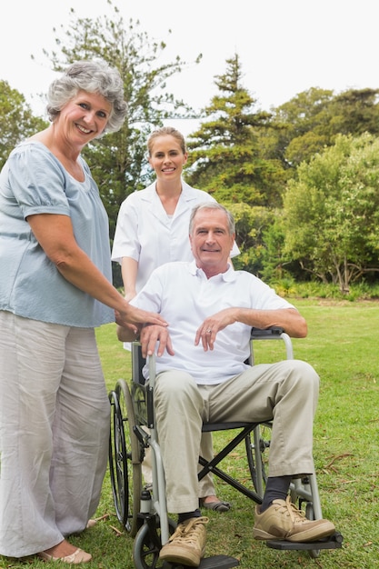 Foto mann im rollstuhl und seine frau und krankenschwester