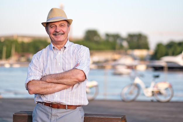 Mann im Sommerhut, der an einem sonnigen Sommertag in der Nähe des Meeres steht