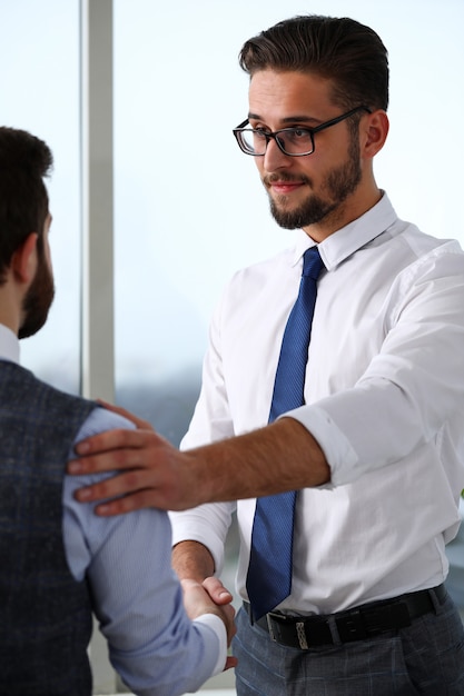 Mann in Anzug und Krawatte geben Hand als Hallo im Büro