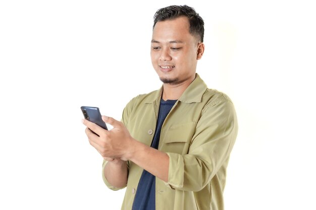 Mann in beige Jacke lächelt, schaut auf Smartphone und macht eine Aktivität
