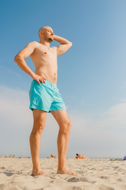 Mann in blauen Badeshorts beim Sonnenbaden am Strand