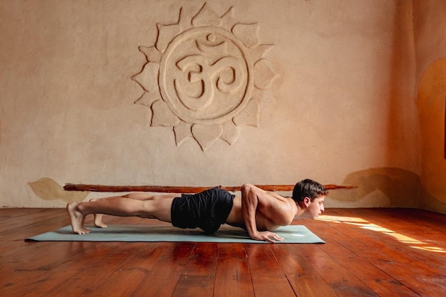 Foto mann in chaturanga-position im yoga-studio gesunder lebensstil