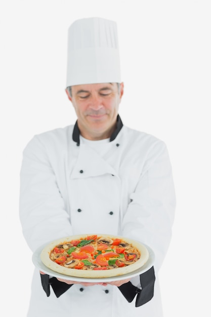 Mann in der Chefuniform, die Pizza hält