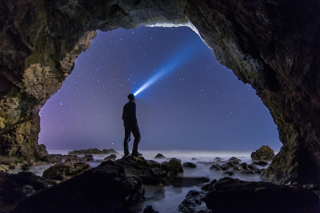 Foto mann in der höhle bei nacht