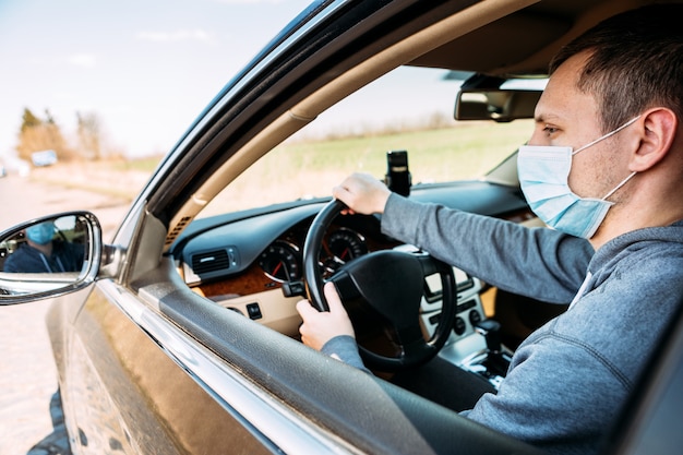 Mann in der medizinischen Maske im Auto. Coronavirus, Krankheit, Infektion, Quarantäne, Covid-19