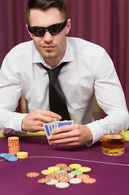 Mann in der Sonnenbrille, die Poker spielt