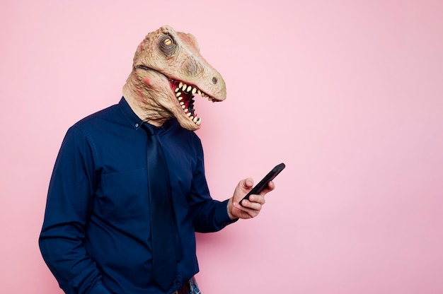 Mann in Dinosauriermaske mit Smartphone
